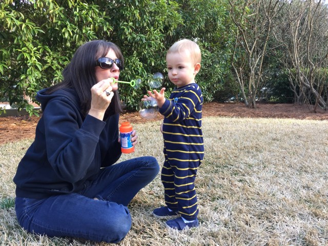 Blowing bubbles in the yard with Gigi.